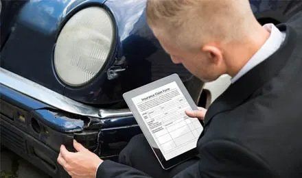 car insurance adjuster reviewing a car
